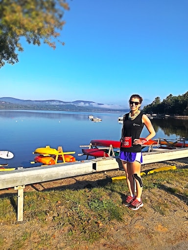 Kristen in front of a lake after a race during the  Adirondack Distance Festival