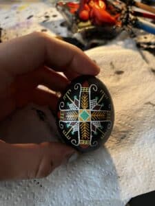 Close-up of Melissa holding a black egg with a painted design